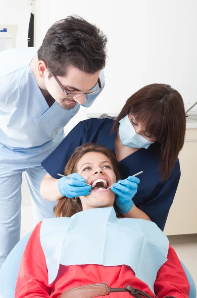 Vrouwelijke tandarts en assistent perfecte tanden te onderzoeken — Stockfoto