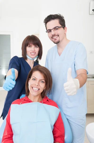 Équipe de dentistes et patient avec pouce levé — Photo