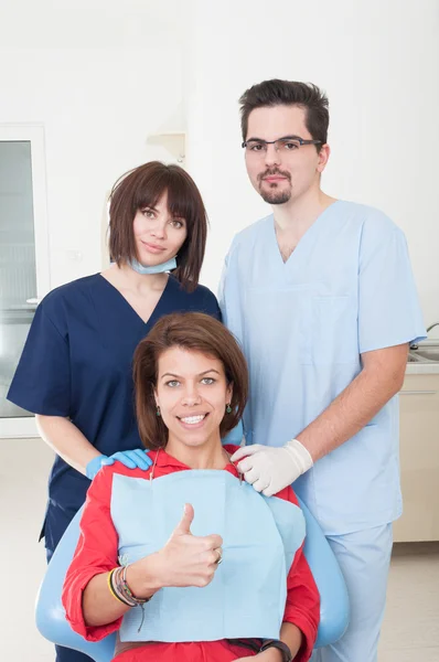 Команда стоматологов заботится о пациентке — стоковое фото