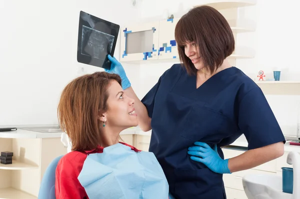 Tandläkare kvinna håller röntgen och ler — Stockfoto