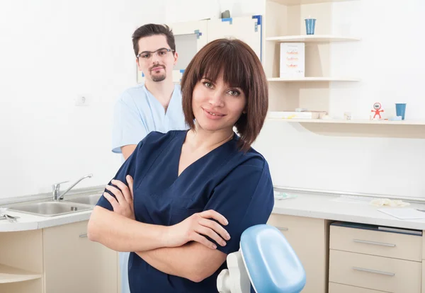 Beautiful and confident dentist woman and male assistant — Stock Photo, Image