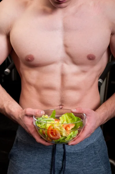 Fit male holding a bowl of salad — Stock Photo, Image