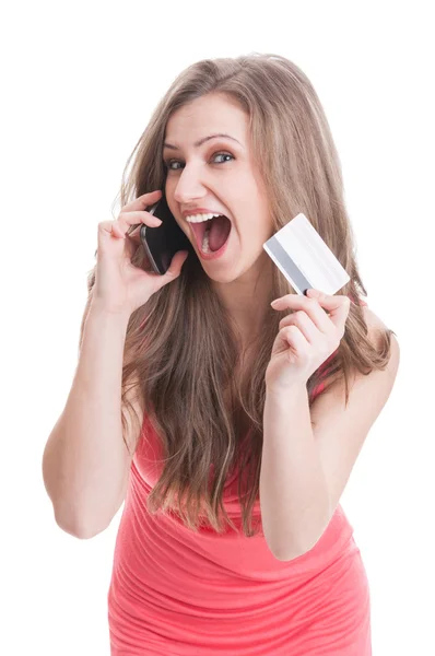 Woman showing a credit card while talking on the phone — Stock Photo, Image