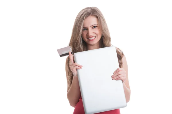 Girl holding closed laptop and a credit card — Stock Photo, Image
