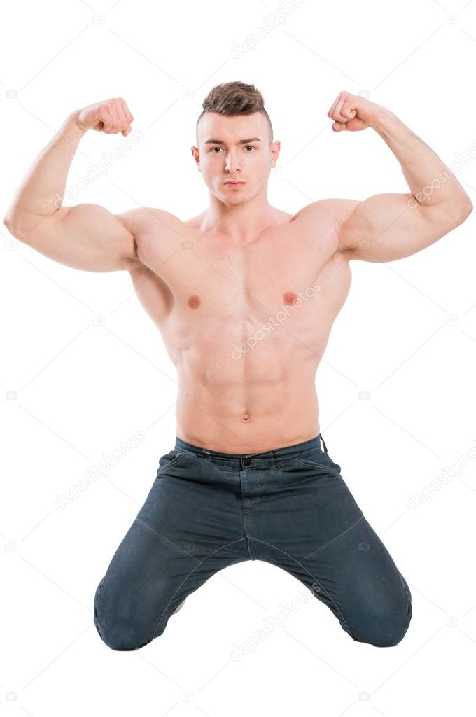 Male model on his knees flexing strong arms