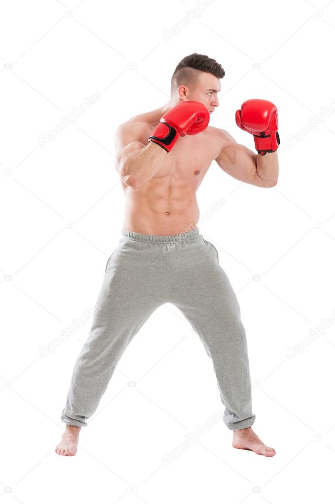 Young and strong, muscular guy wearing boxing gloves