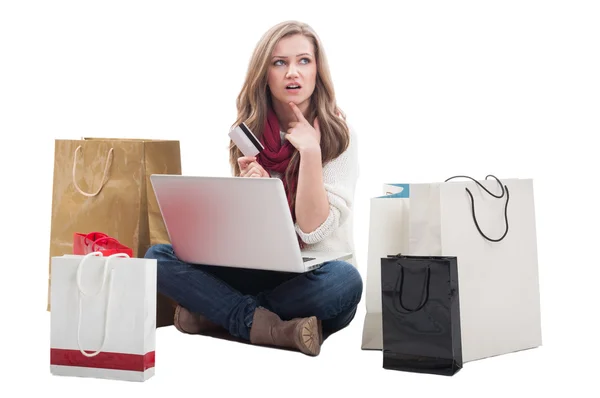 Worried shopping woman holding card and thinking — Stock Photo, Image