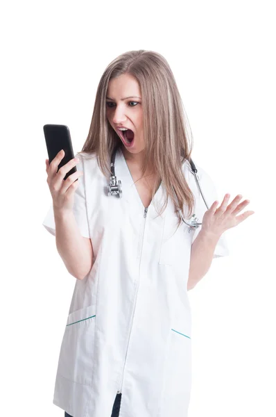 Surprised woman doctor looking at smartphone — Stock Photo, Image