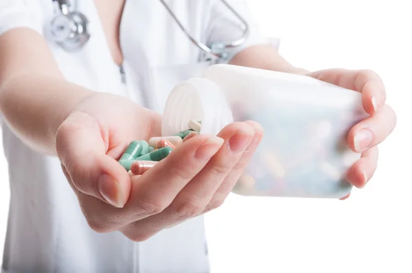 Woman doctor pouring pills on hand — Stock Photo, Image
