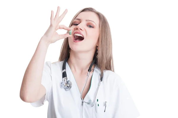 Woman doctor taking a green natural pill — Stock Photo, Image
