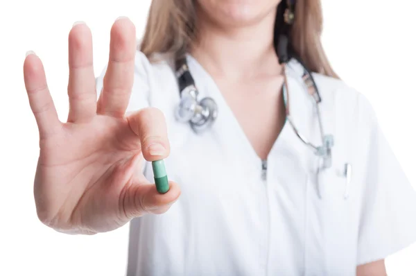 Female doctor holding and offering one green pill — Stock Photo, Image