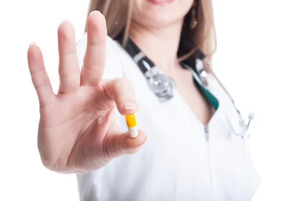 Female doctor offering a yellow vitamin pill — Stock Photo, Image