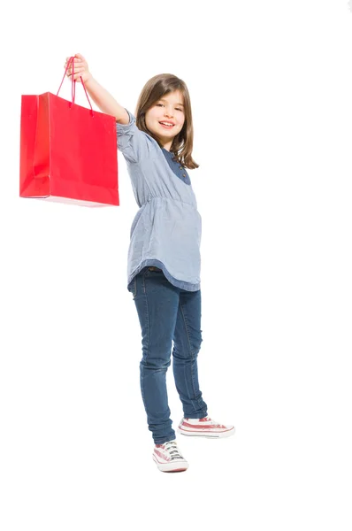 Joven y linda chica de compras sosteniendo una bolsa roja — Foto de Stock