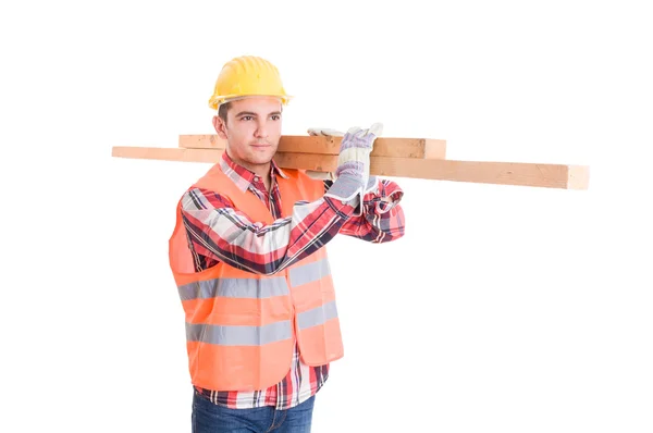 Constructor con casco amarillo llevando maderas —  Fotos de Stock
