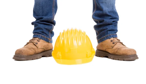 Bouw werknemer voeten en gele helm — Stockfoto