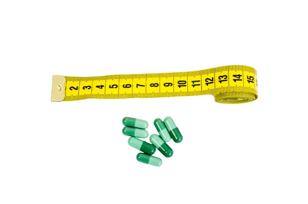 Medidor de alfaiate e pílulas de ervas verdes — Fotografia de Stock