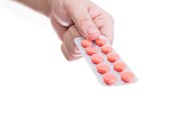 Mão segurando pílulas vermelhas blister — Fotografia de Stock