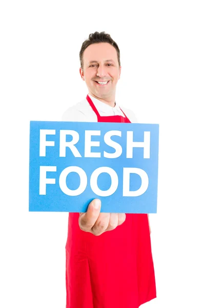 Supermarkt-Mitarbeiterin hält Schild mit frischen Lebensmitteln — Stockfoto
