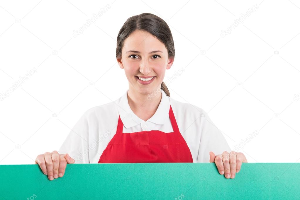 Female supermarket employee holding green board