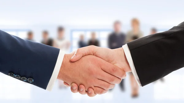 Empresarios estrechan la mano con gente de negocios de fondo —  Fotos de Stock