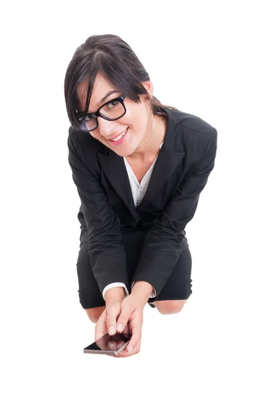 Business woman sitting on crouches and holding smartphone — Stock Photo, Image