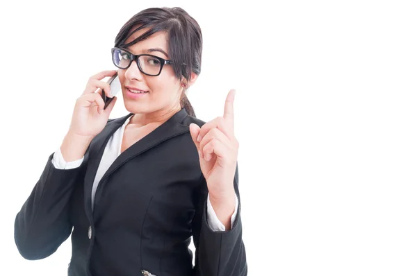 Saleswoman talking on the phone and making wait gesture — Stock Photo, Image
