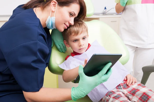 Modern dentist use wireless tablet with kid patient — Stok fotoğraf