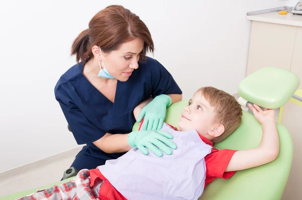Dentist woman talking with kid patient — Stock Photo, Image