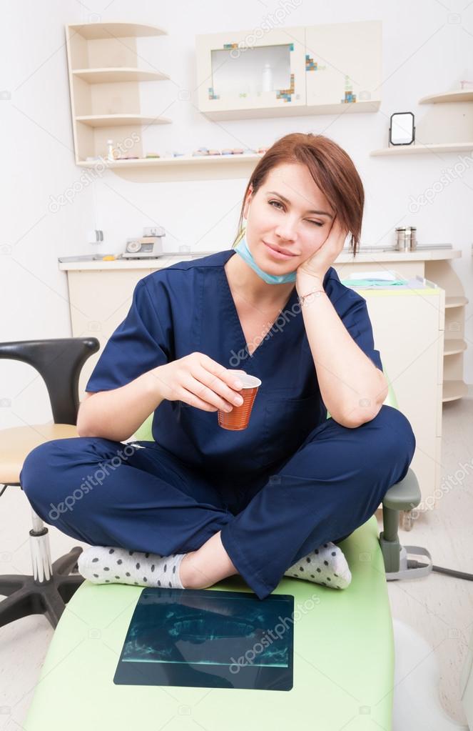 Tired female dentist doctor taking a coffee break