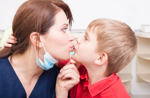Daring and bold kid kissing dentist woman — Stok fotoğraf