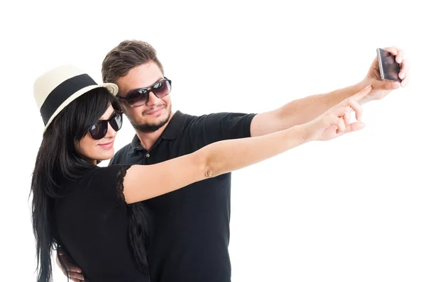 Young couple wearing shades and taking a selfie — ストック写真