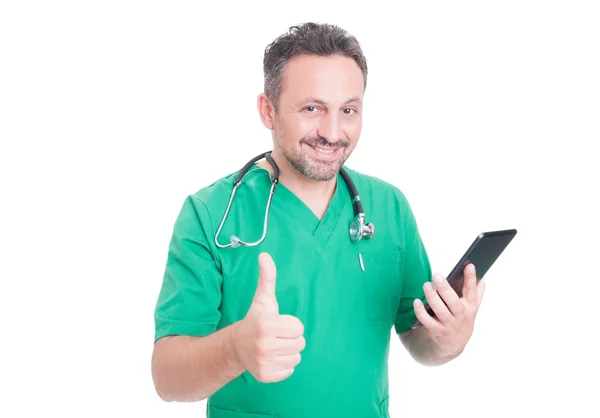 Médico positivo sosteniendo el comprimido y mostrando como —  Fotos de Stock