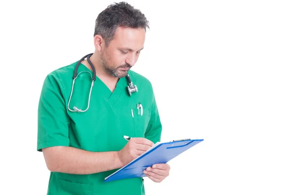 Médico ocupado escribiendo en el portapapeles —  Fotos de Stock