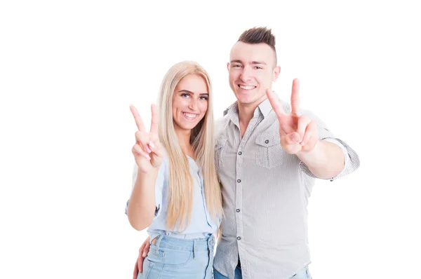 Lovely young couple showing peace or victory sign — Stock Photo, Image