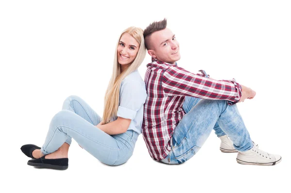 Красивая молодая пара сидит на полу спиной к спине — стоковое фото