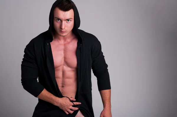 Hübsche männliche Modell posiert nackt mit einem Kapuzenpullover — Stockfoto