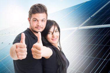 Mutlu bir çift gibi güneş enerjisi fotovoltaik panel arkasında gösterilen
