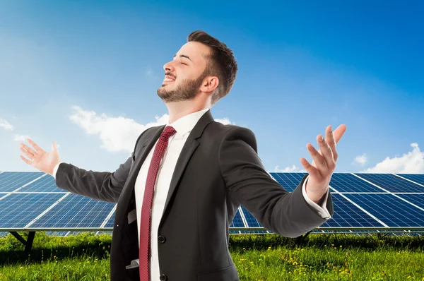 Successful businessman with outspread arms on solarpower photovo — Stock Photo, Image