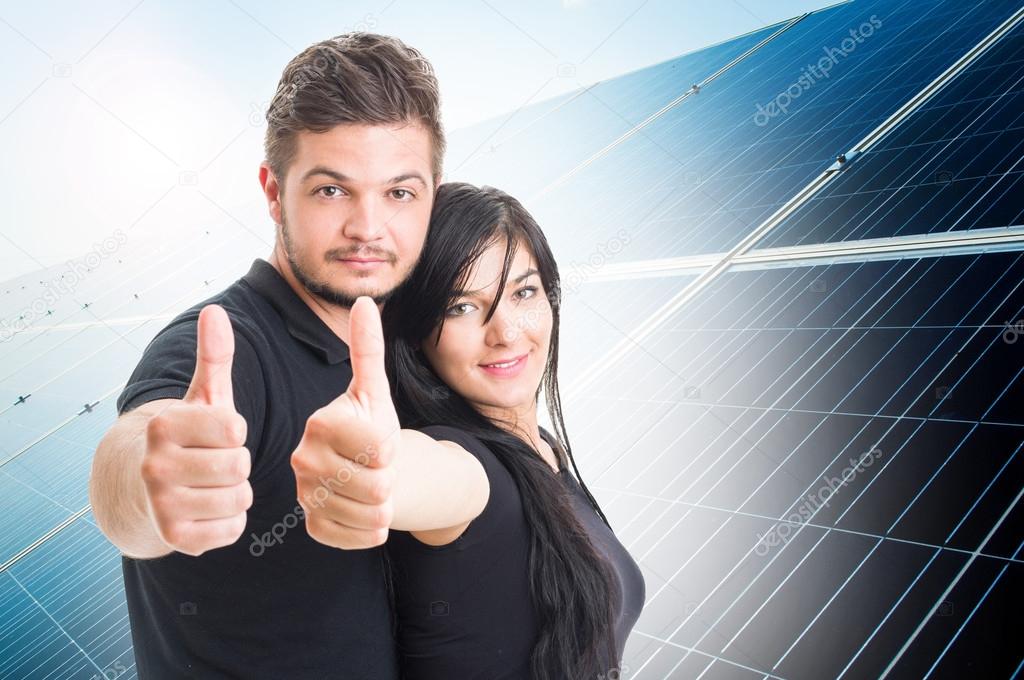 Happy couple showing like on solar power photovoltaic panel back