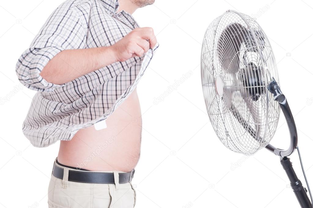 Man with open shirt standing in front of blowing fan