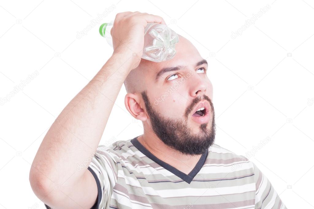 Man cooling his head with cold water in plastic bottle