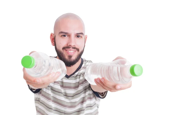 Hombre sonriente ofreciendo o dando dos botellas de agua fría — Foto de Stock