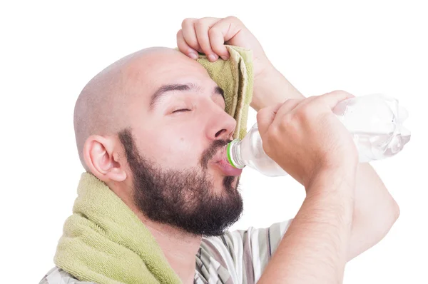 Hombre bebiendo agua y limpiando la frente sudorosa — Foto de Stock