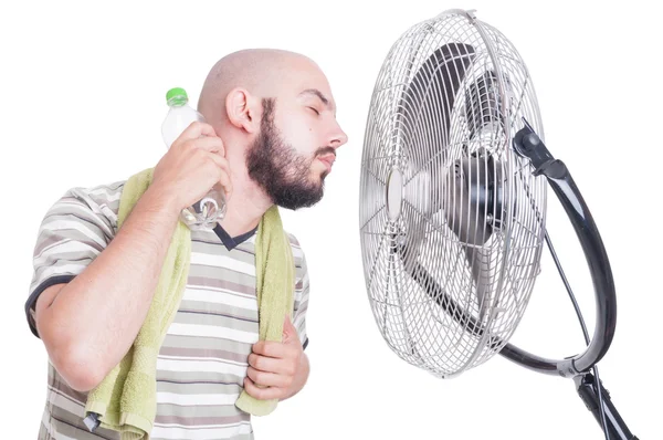 Hombre enfriando su cuello con botella de agua fría y ventilador — Foto de Stock