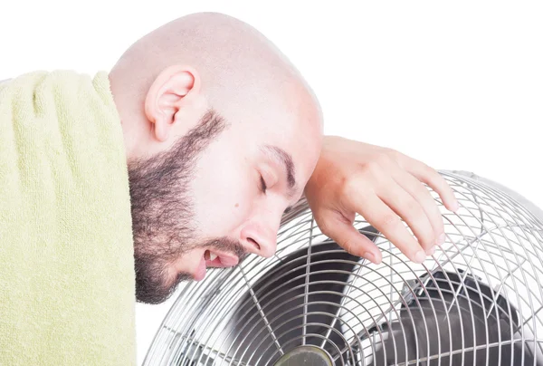 Exhausted man resting on blowing fan or cooler — Stock Photo, Image