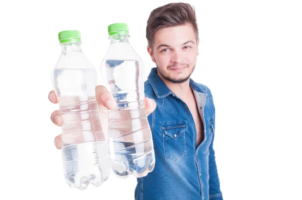 Bello modello maschile che offre due bottiglie di acqua fredda — Foto Stock