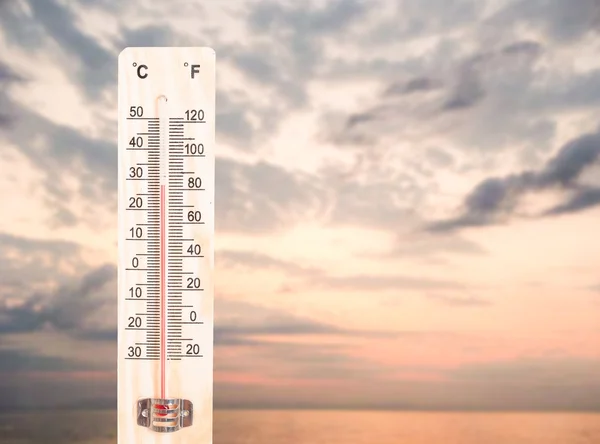 Thermometer on ocean or sea sunset background — Stock Photo, Image