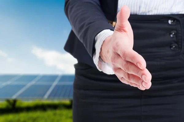 Mulher de negócios oferecem aperto de mão no fundo do campo de energia solar — Fotografia de Stock