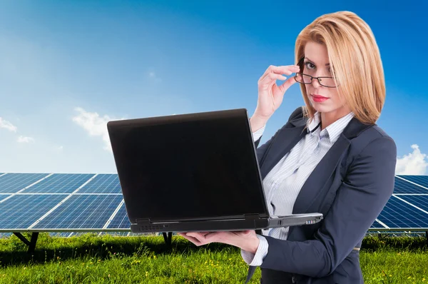 İş kadını ile arka planda güneş enerjisi Santrali — Stok fotoğraf