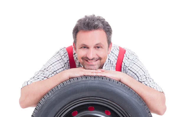 Amistoso mecánico descansando cabeza sobre neumático — Foto de Stock